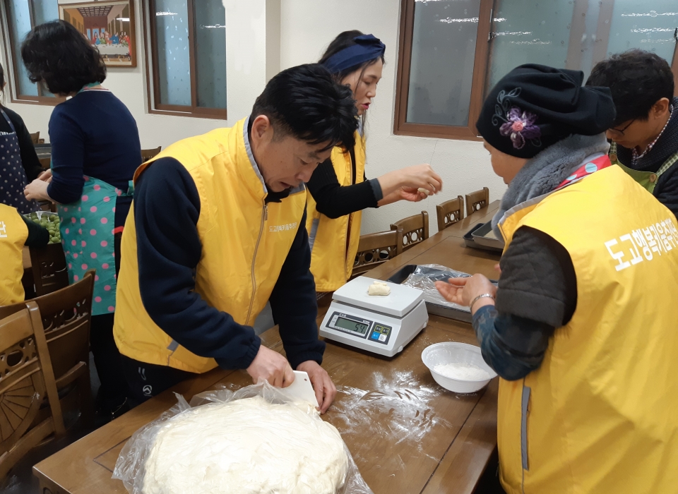 제빵봉사 활동에 참여한 도고면 행복키움추진단과 이정희 도고면장이 빵을 만들고 있다.
