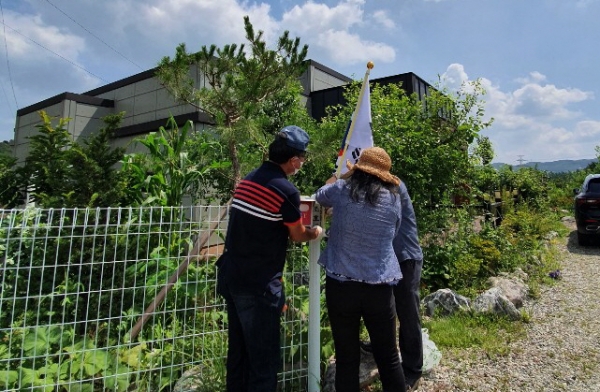 귀농귀촌협의회 회원들이 태극기 걸이를 설치하고 있다.
